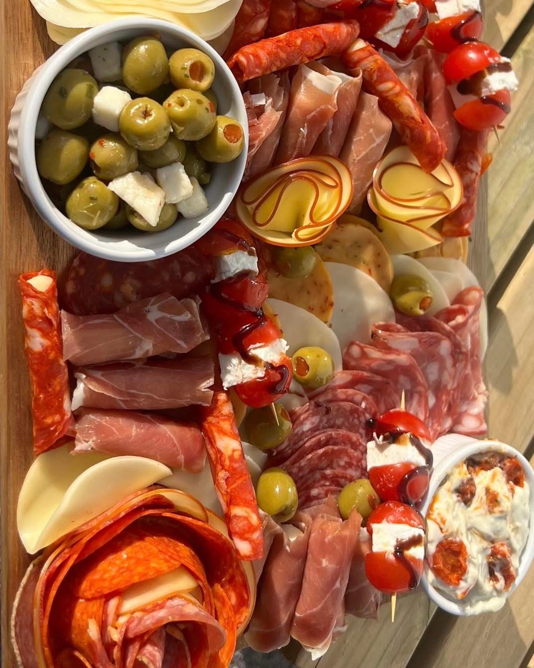 Charcuterie and cheese board with olives, cured meats and antipasti