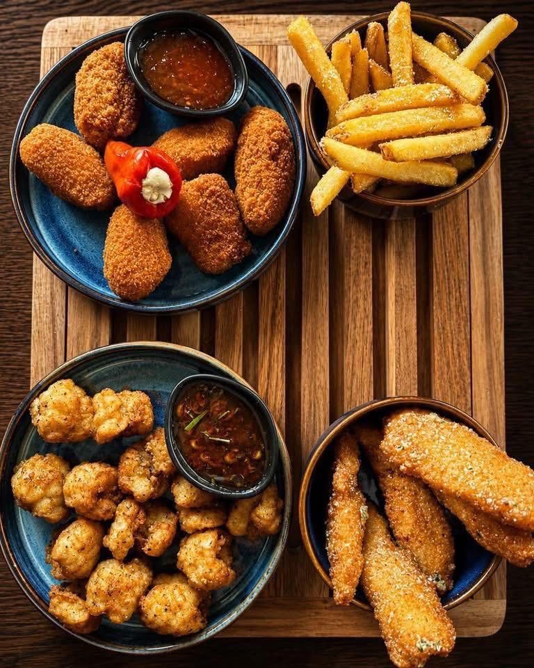 Sharing platter with breaded bites, halloumi fries and dips